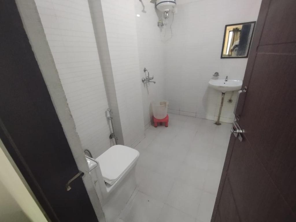 a white bathroom with a toilet and a sink at Zaranka Camps in Hisār