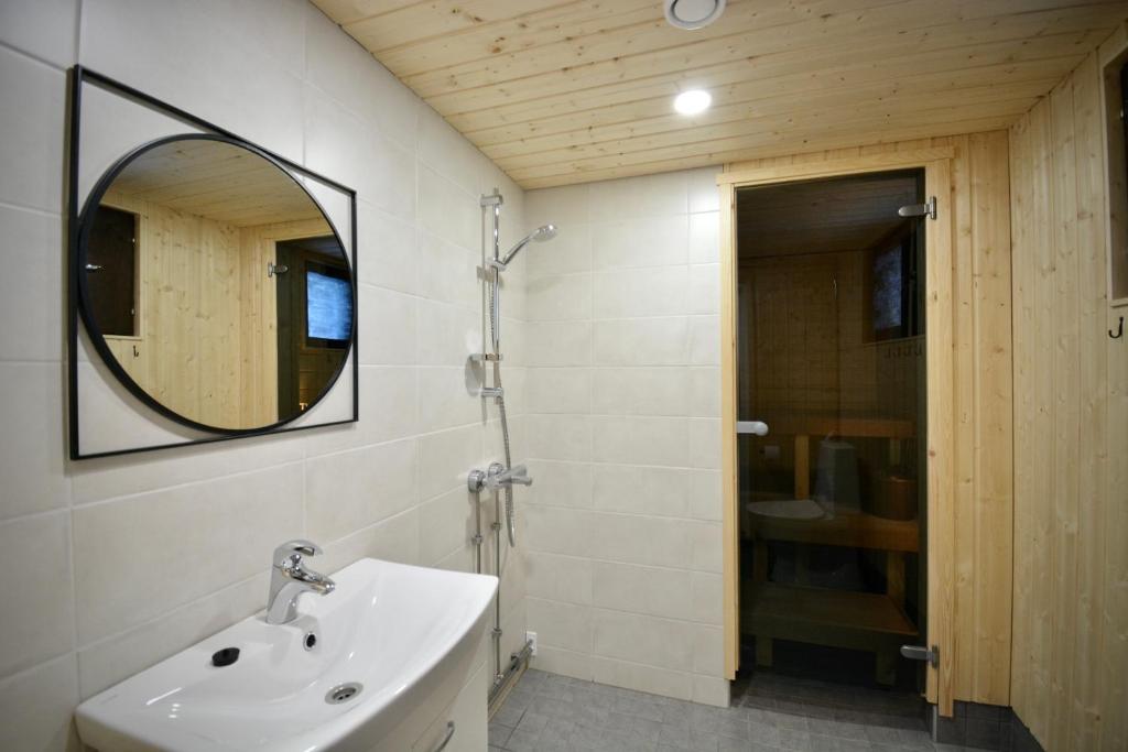 uma casa de banho com um lavatório e um espelho em Aava Sky Village Aurinkomaja em Aavasaksa
