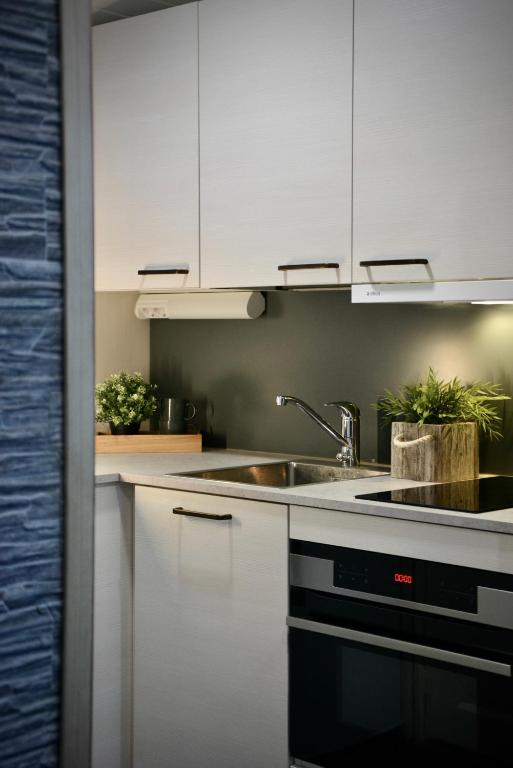 a kitchen with white cabinets and a sink at Aava Sky Village Aurinkomaja in Aavasaksa
