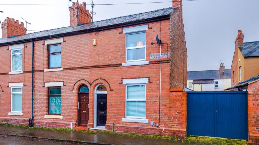 an old red brick building with a blue gate at Perfect for Business Guests or Leisure in Hough Green