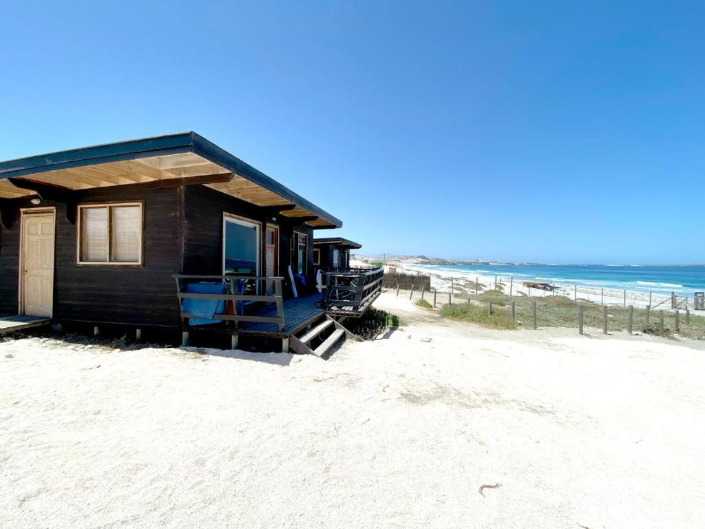 a house on a beach with the ocean in the background at Punta de Choros Lodge in Punta de Choros