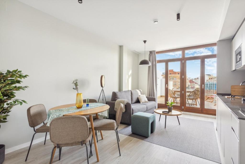 a living room with a table and a couch at Limehome Valencia Calle de Cadiz in Valencia