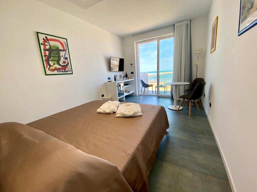 1 dormitorio con 1 cama en una habitación con ventana en Marina Bay Beach Hotel, en Peschici