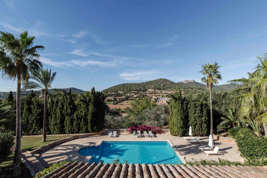 an outdoor swimming pool with palm trees and a resort at C'an Talaieta Luxurious Farmhouse in S'Horta