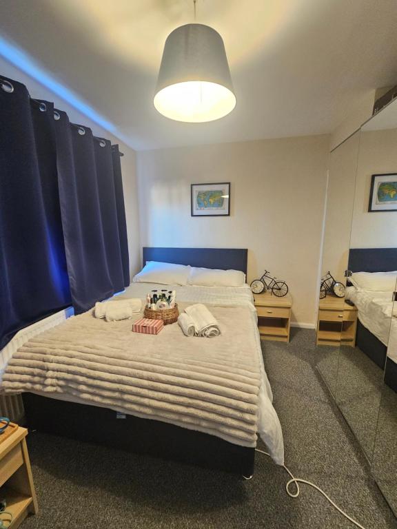 a bedroom with a large bed with blue curtains at Double bedroom located close to Manchester Airport in Wythenshawe