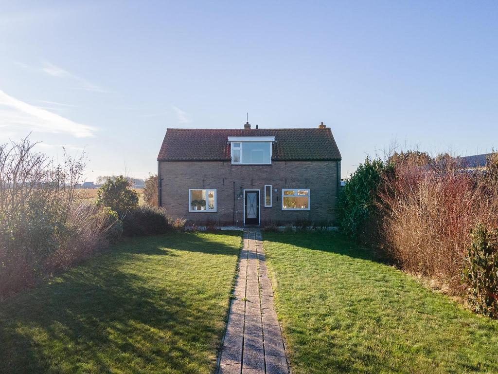 een huis op een grasveld met een pad dat er naar toe leidt bij Vakantiehuis Rust in de onruste in Kamperland