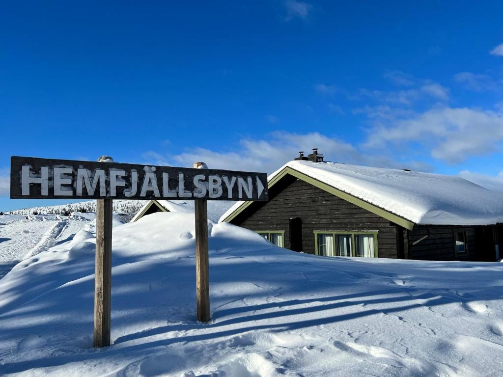 a street sign in the snow in front of a house at Hemfjällsbyn 17A in Sälen