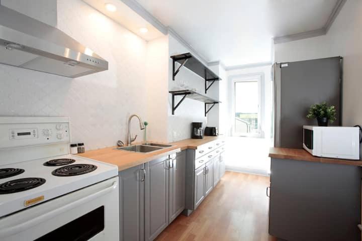 a kitchen with a white stove and a sink at Cozy Airport 2-bed in Winnipeg