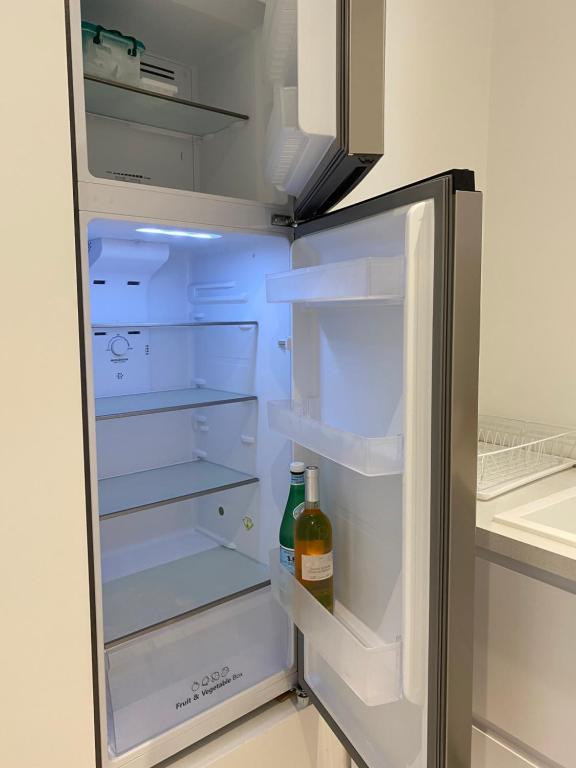 un frigorifero aperto con una bottiglia di vino di HELLO 2 pièces “rénové et climatisé “ Vieil Antibes a Antibes