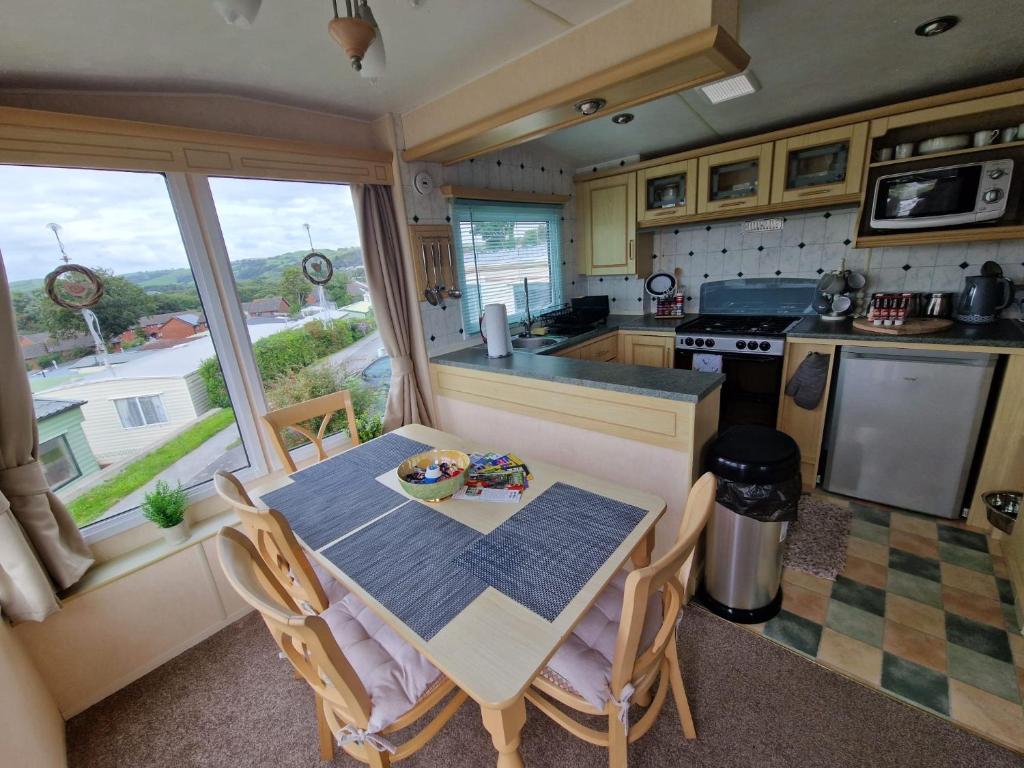 a kitchen with a table and chairs and a kitchen with a window at Caravan F7 Aberystwyth holiday village in Aberystwyth