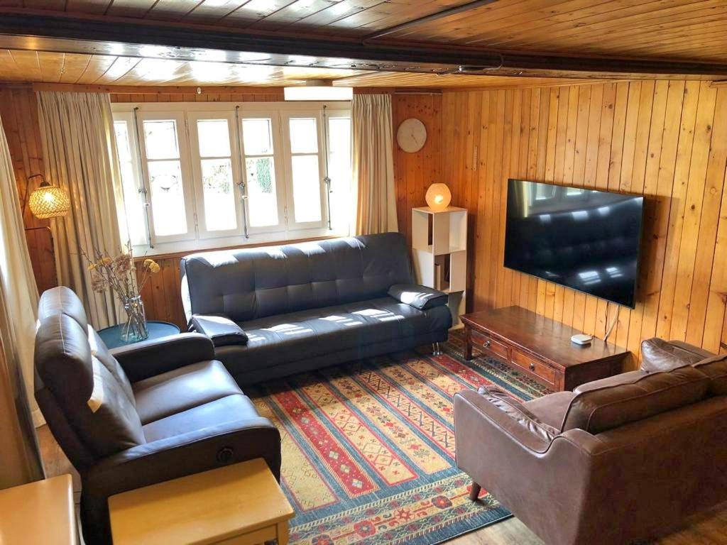 uma sala de estar com um sofá e uma televisão de ecrã plano em Cosy mountain apartment 5min walk from Gondola em Fiesch