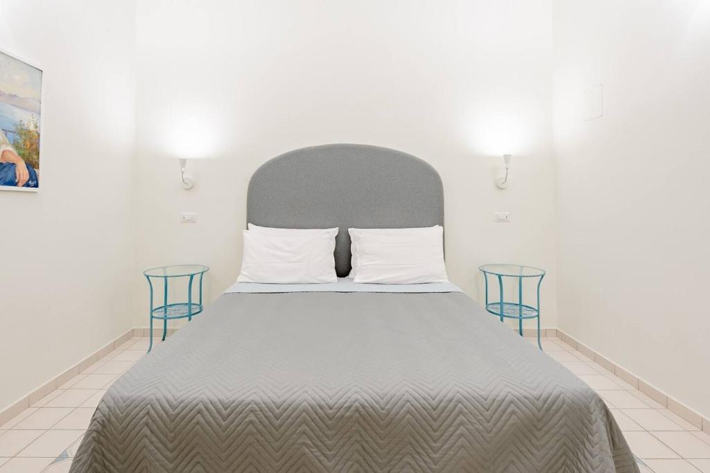 ソレントにあるRosa Magra Guest Houseのベッド1台(グレーのヘッドボード、椅子2脚付)