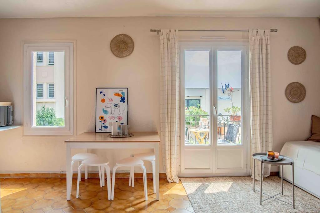 a living room with a table and chairs and a couch at Appartement climatisé en plein centre avec balcon in Saint-Jean-Cap-Ferrat