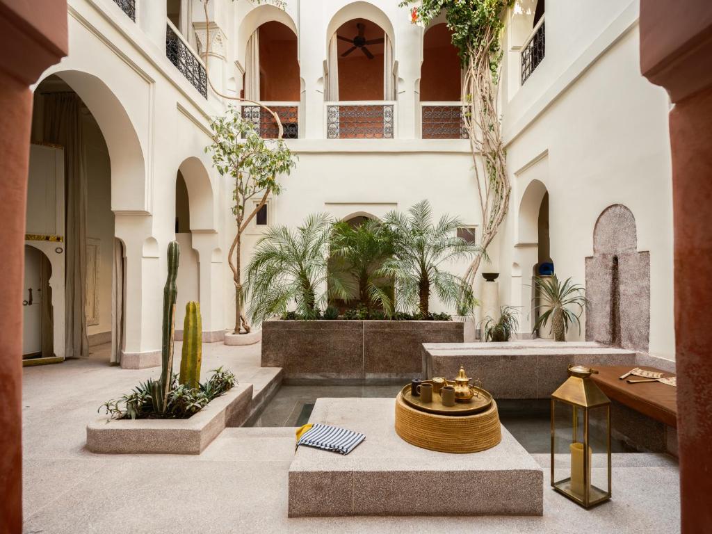 a courtyard with a fountain in a building with palm trees at Riad Brummell Medina in Marrakesh