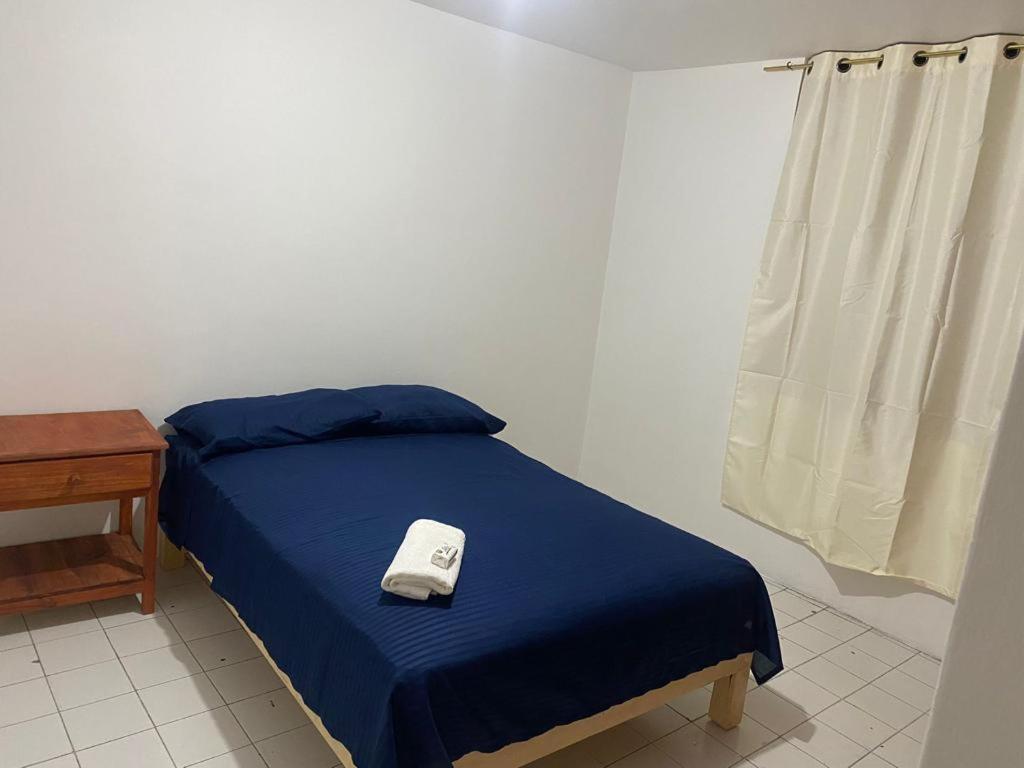 1 dormitorio con 1 cama con manta azul y mesa en Cómodo departamento en Naciones unidas, en Guadalajara
