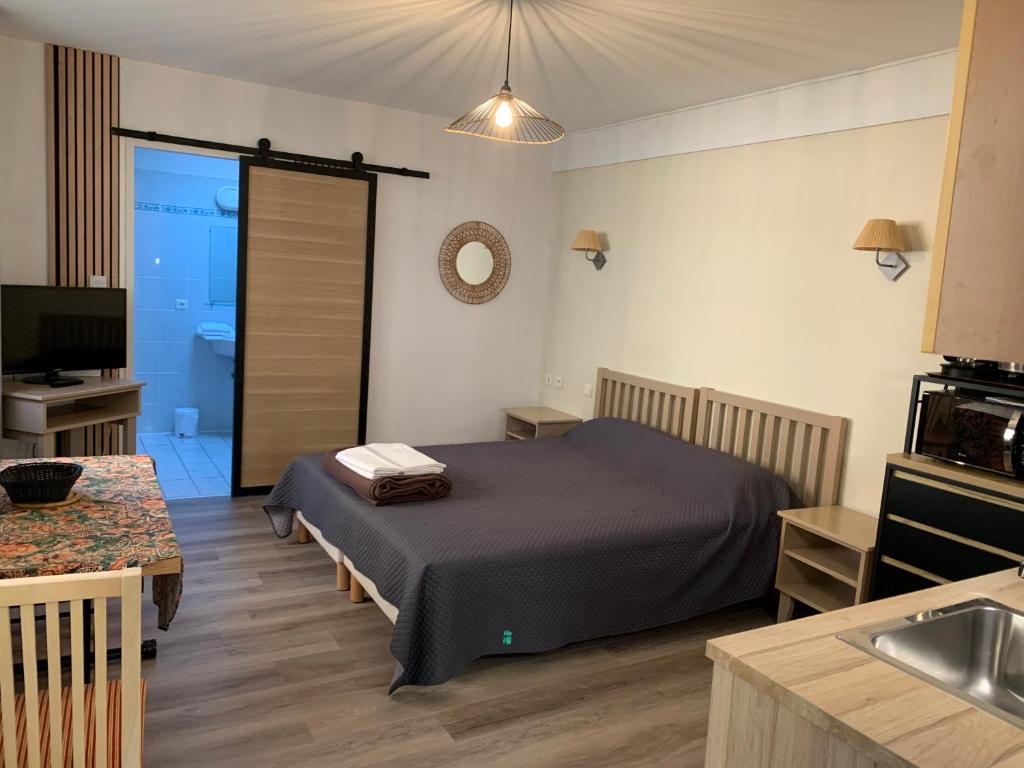 a bedroom with a bed and a kitchen with a sink at Résidence Le Rochebonne in Saint Malo