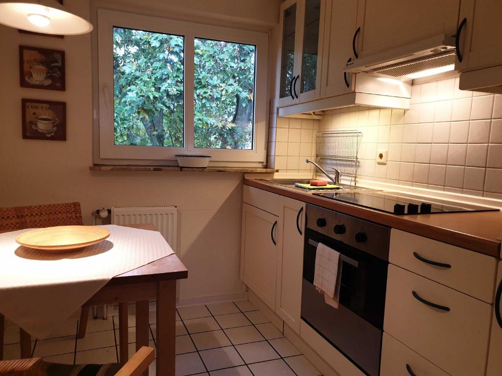 a kitchen with a stove and a table and a window at Deichgräfin 4 in Horumersiel
