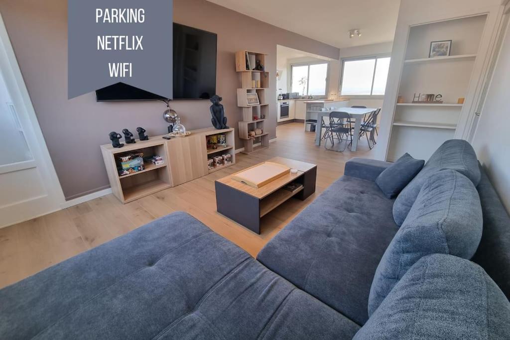 - un salon avec un canapé bleu et une table dans l'établissement Le Landouzy - Parking - Netflix - Wifi, à Chamalières