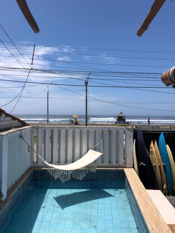 a hammock on the back of a house with the beach at Pointbreak Surf Camp in Huanchaco
