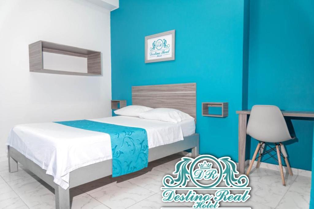 een slaapkamer met een bed en een blauwe muur bij Destino real hotel in Arauca