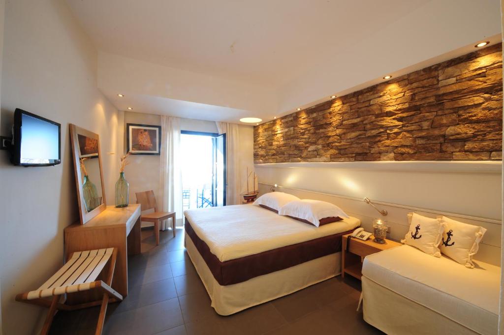 a hotel room with two beds and a stone wall at Vrahos Boutique Hotel in Karavostasi