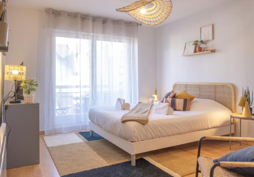 une chambre avec un lit et une grande fenêtre dans l'établissement Parking - L'Ambre - Balcon, à Strasbourg