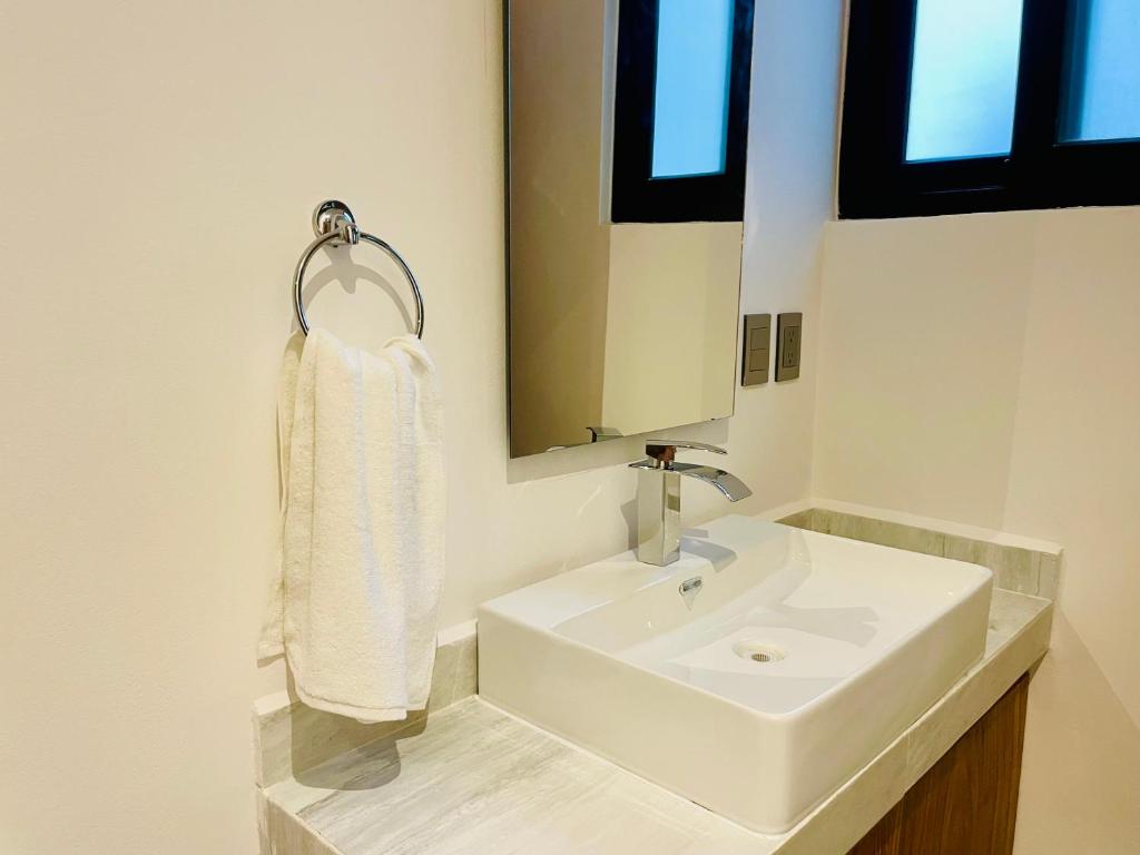 une salle de bains avec un lavabo blanc et un miroir dans l'établissement DOI 45 Apartment, à Playa del Carmen
