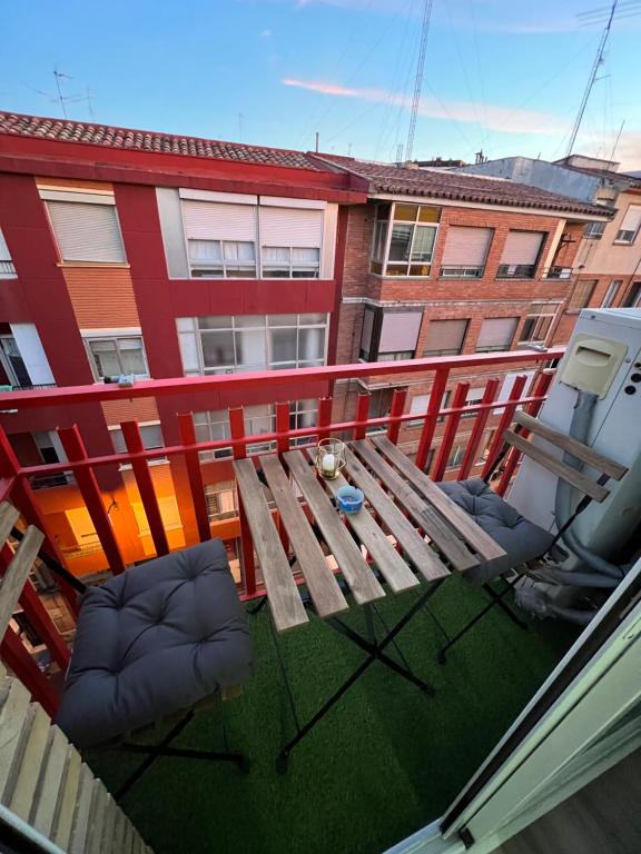 Apartamento en Zaragoza con parking في سرقسطة: إطلالة علوية على طاولة وكراسي خشبية على شرفة