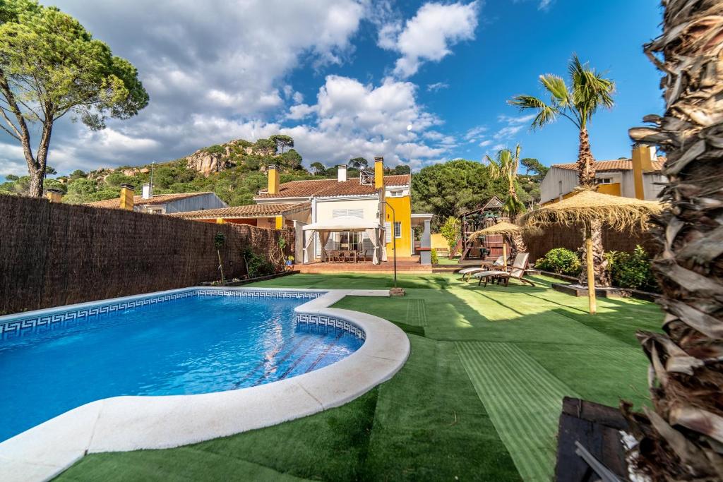 an exterior view of a house with a swimming pool at Casa El Oasis del Lago Alojamiento Rural in Córdoba