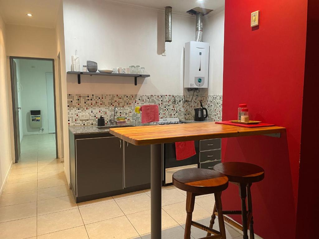 une cuisine avec un comptoir en bois et deux tabourets dans l'établissement Departamento Moderno en Costanera Rambla, à Gualeguaychú