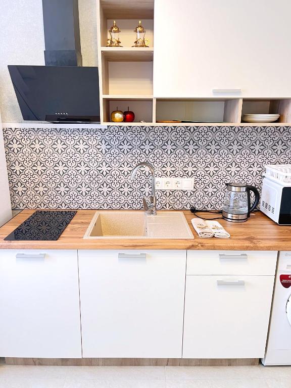 a kitchen with white cabinets and a sink at Go to Aibike in Promyshlennyy