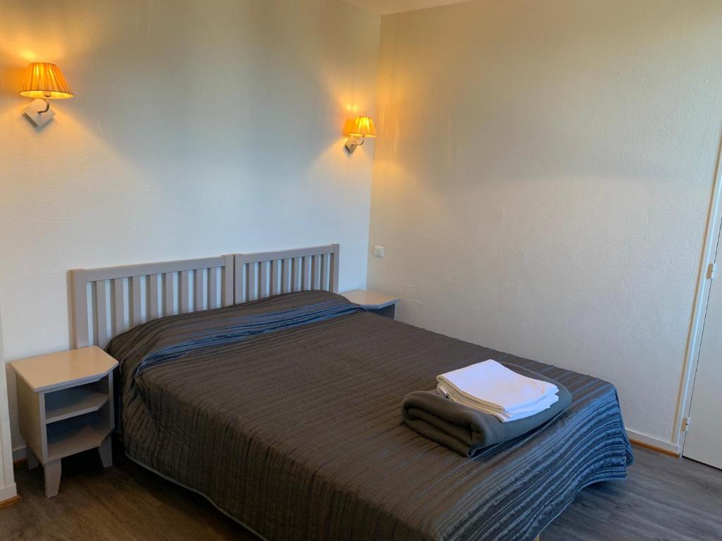 a bedroom with a bed with two towels on it at Résidence Le Rochebonne in Saint Malo