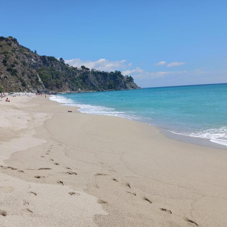 a beach with footprints in the sand and the ocean at Andi in Stalettì
