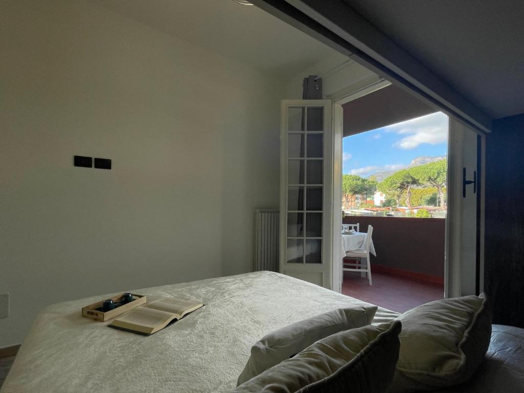 una camera con un letto e una grande finestra di [Il Gabbiano] Bilocale con Piscina, Garage e A/C. a Loano