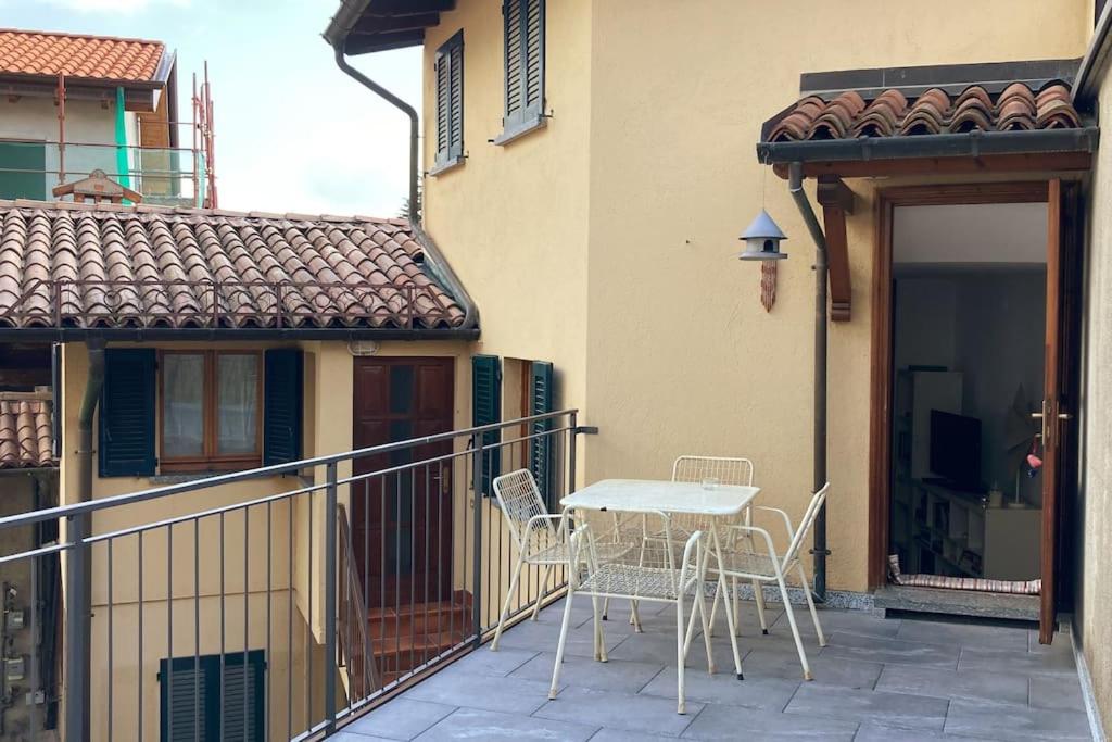 een patio met een tafel en stoelen op een balkon bij La Corte del Fauno in Viggiù