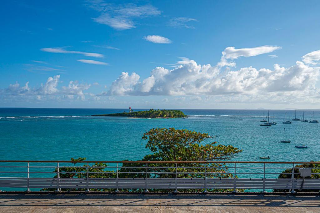 an island in the ocean with boats in the water at ILET TURQUOISE in Le Gosier