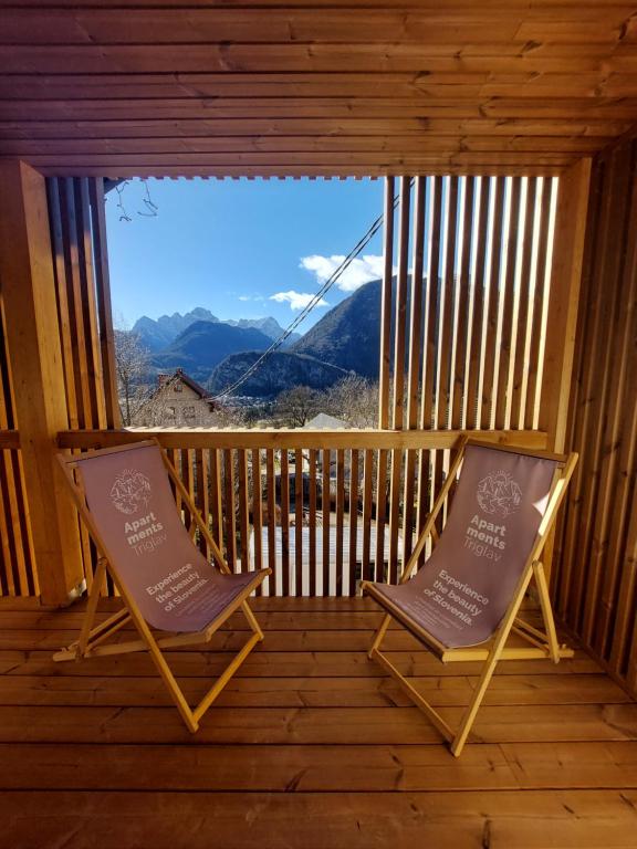 2 sillas sentadas en un porche con vistas en Apartments Triglav, en Mojstrana