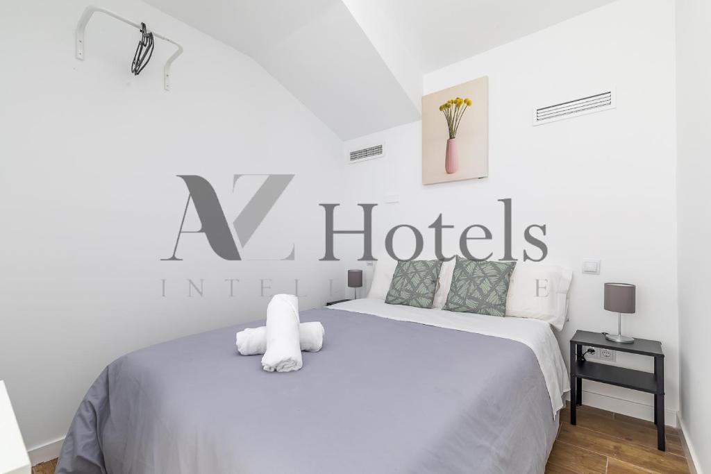 un dormitorio blanco con una gran señal de hotel en la pared en AYZ Luis Cabrera-Auto check-in property, en Madrid