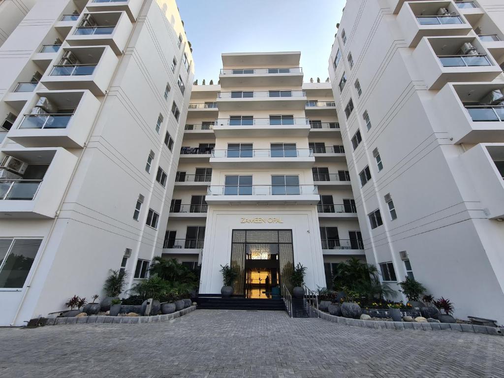 a building with two large white buildings at 1 Bed Modern Apartment, Pool, Gym, Cinema in Lahore