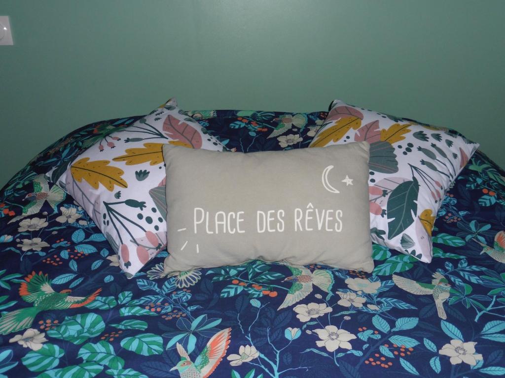 - un oreiller sur un lit avec une couverture florale dans l'établissement Gîte 4 pers avec option sauna- Classé 3 étoiles- Sud charente, 