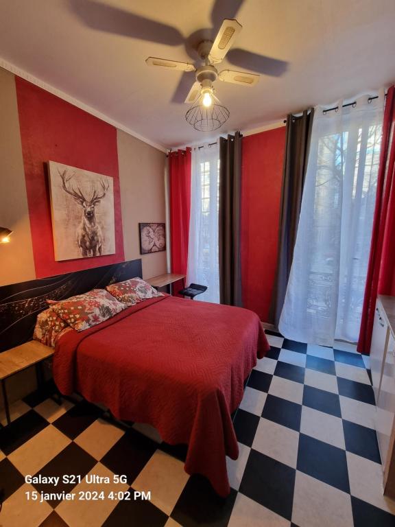 1 dormitorio con cama roja y suelo a cuadros en Hôtel des allées, en Marsella