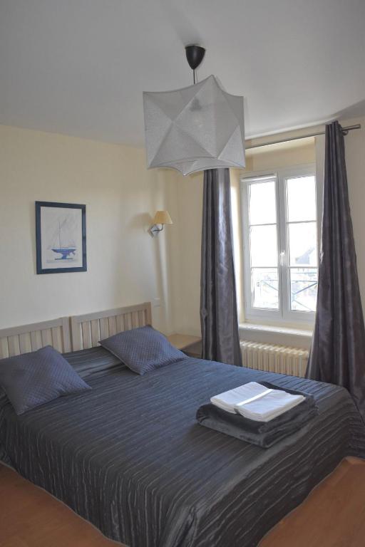 a bedroom with a large bed and a window at Résidence Le Rochebonne in Saint Malo