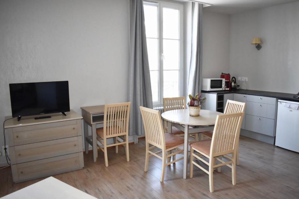 a kitchen and dining room with a table and chairs at Résidence Le Rochebonne in Saint Malo