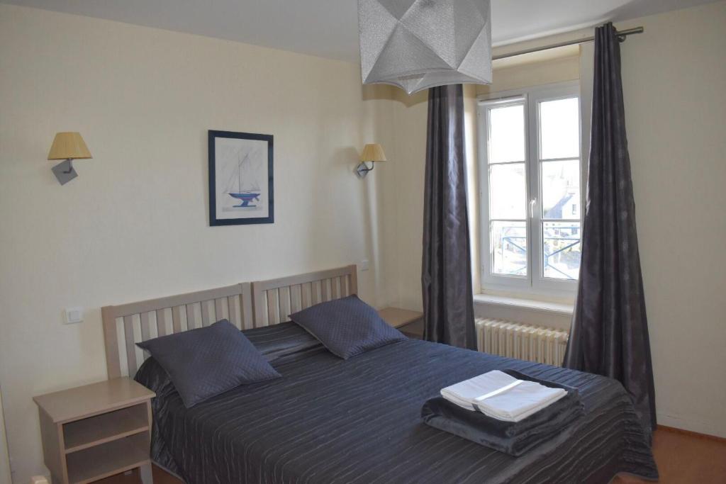 a bedroom with a bed with two towels on it at Résidence Le Rochebonne in Saint Malo