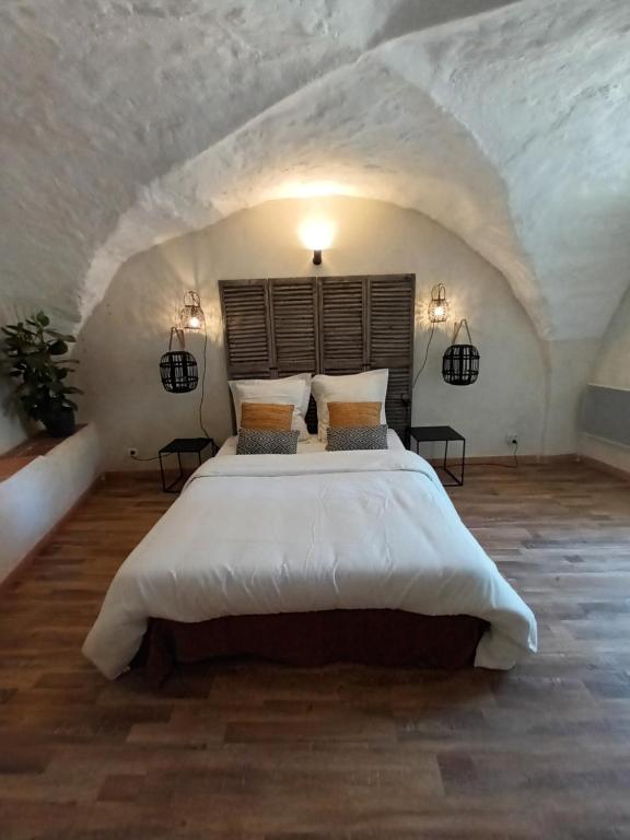 une chambre avec un grand lit dans un grenier dans l'établissement Bastide la Bohême, à Ollioules