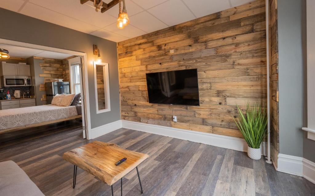 salon z drewnianą ścianą i telewizorem z płaskim ekranem w obiekcie Rustic Riverfront Retreat w mieście Harrisburg
