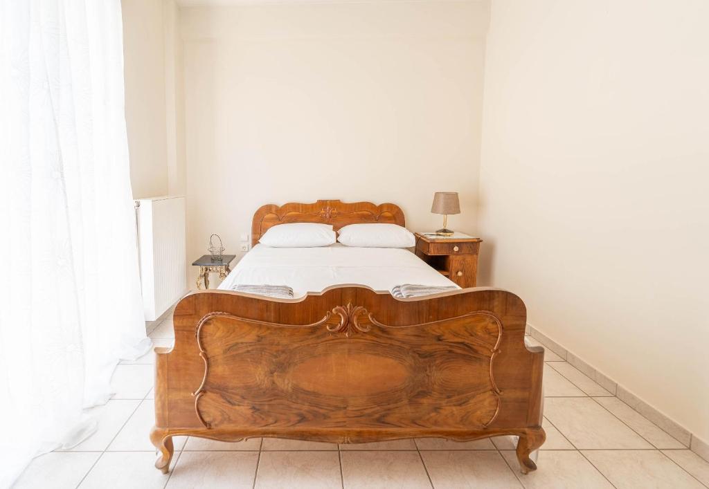 - une chambre avec un lit en bois dans l'établissement Vintage Family Comfort By Greece Apartment, à Aigio