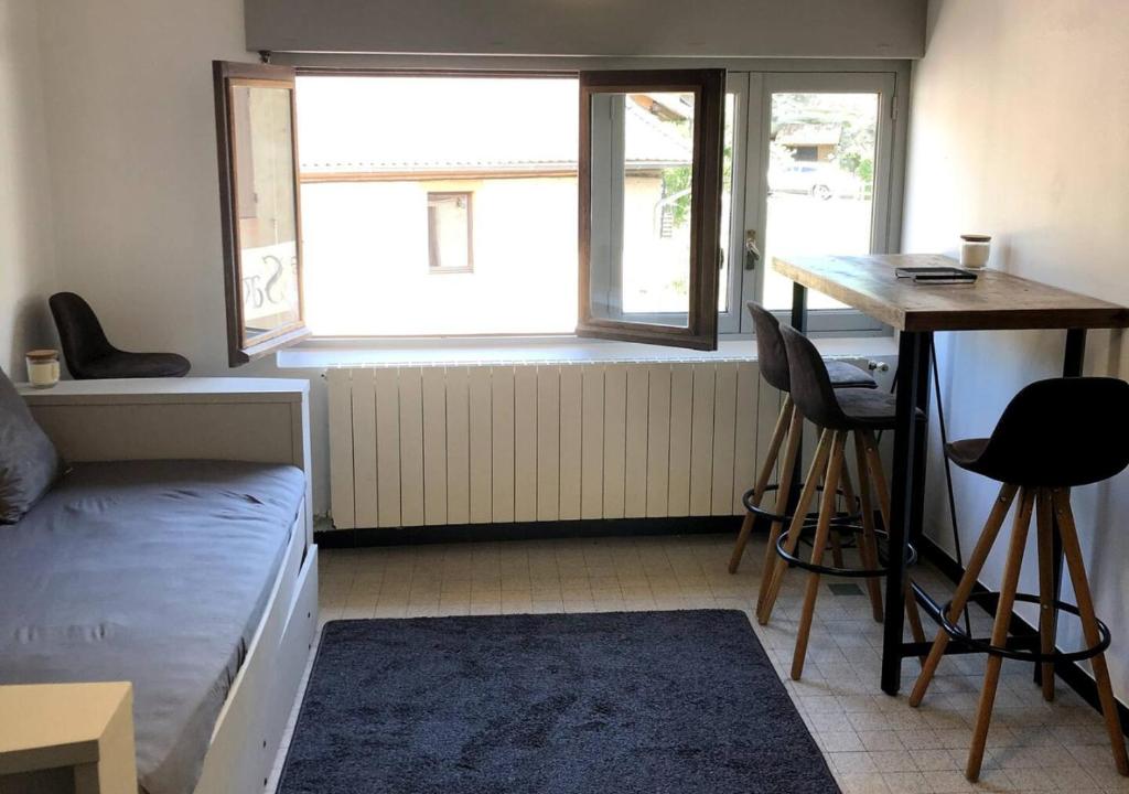 Zimmer mit einem Bett, einem Schreibtisch und einem Fenster in der Unterkunft Studio à 20 min de Walibi in Le Pont-de-Beauvoisin