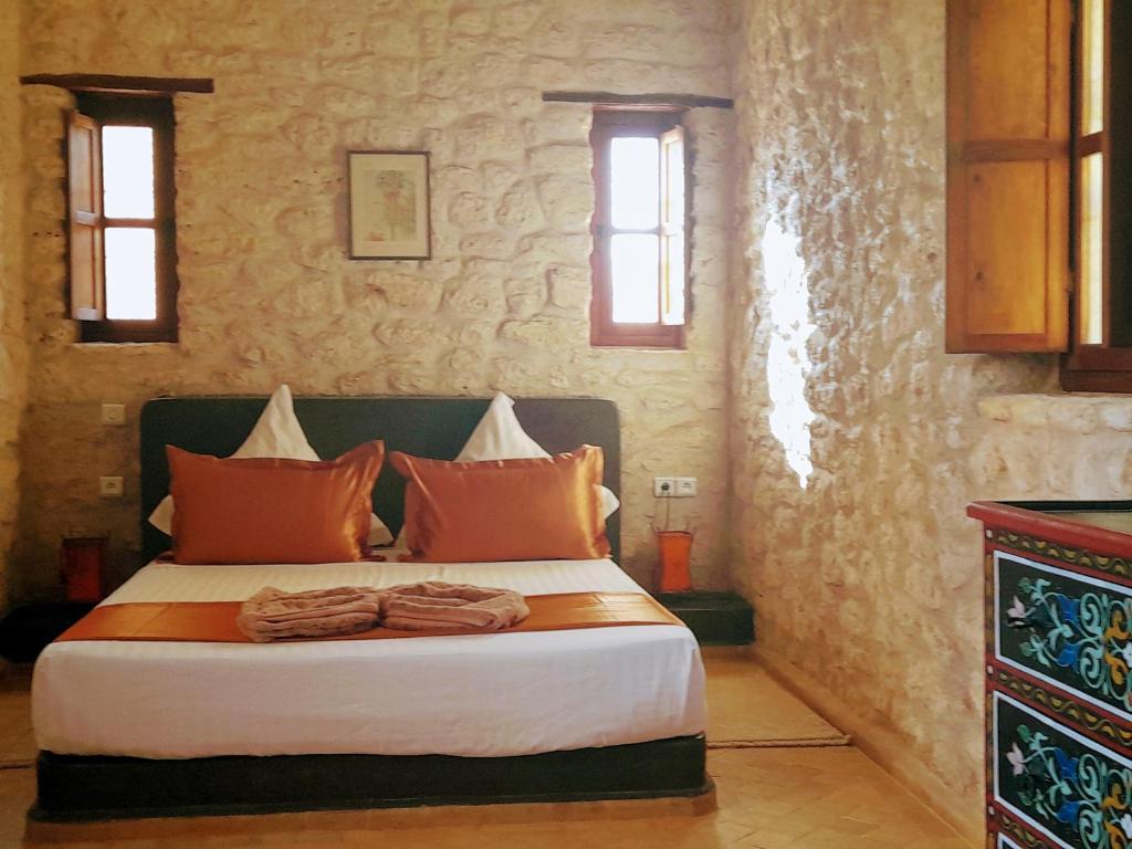 a bedroom with a large bed with orange pillows at Riad Mamy Wababi in Essaouira