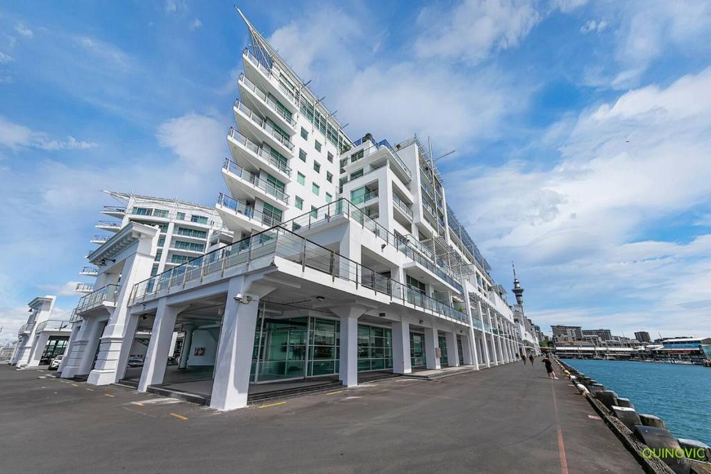 een groot wit gebouw naast het water bij AWSA Deluxe Waterfront (4004) in Auckland